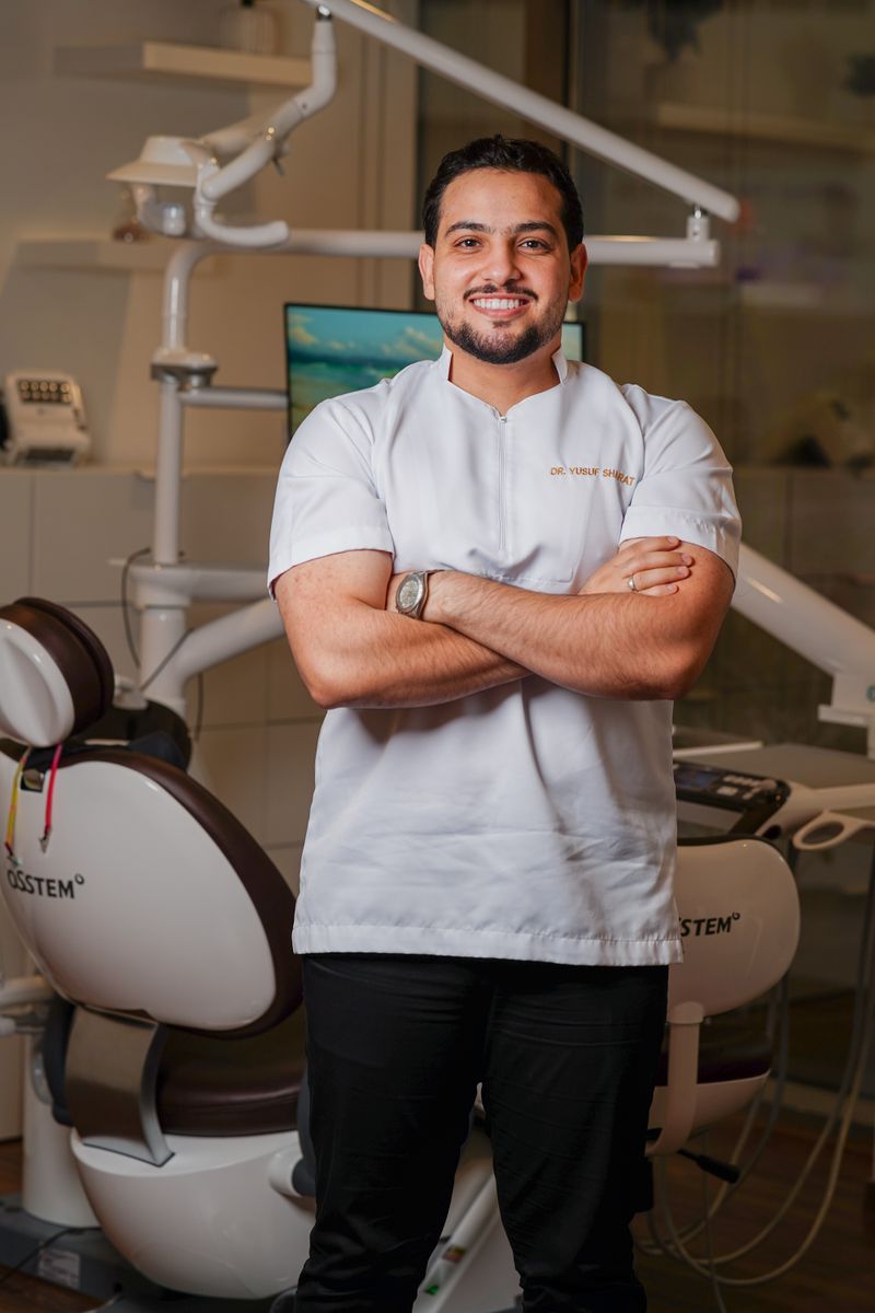 A confident physiotherapist in clinic attire, ready for patient care.